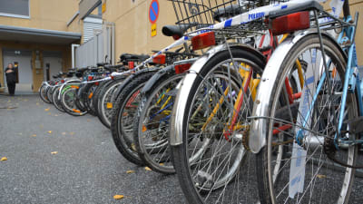 Upphittade cyklar på polisens bakgård i Vasa. I bakgrunden byråsekreterare Ann-Louise Olén.