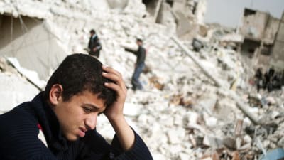 En syrisk tonåring i ruinerna efter en missilattack i Aleppo i Syrien
