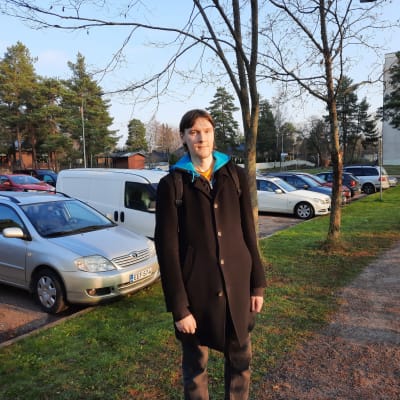 Juhani Liimatainen står vid en parkeringsplats.