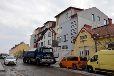 En liten lastbil står vid en byggarbetsplats i ett flervåningshus.