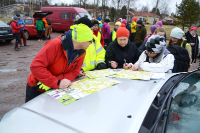 Frivilliga vid kartor som de delar upp i områden som de ska leta efter Harry Karjalainen på.