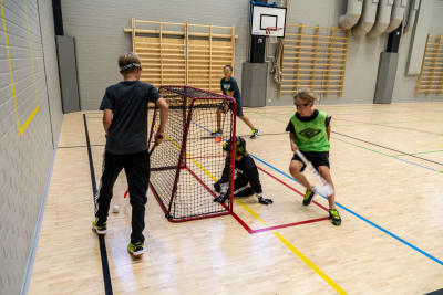 Unga spelar innebandy.