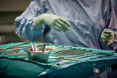Kirurgiska instrument upplagda på bord i operationssal. 