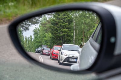Bilar syns i en bils sidospegel.