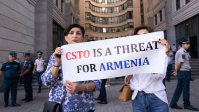 Kaksi naista pitelee kylttiä, jossa lukee englanniksi: "CSTO on uhka Armenialle."