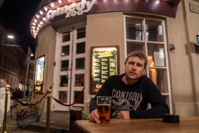 Man sitter med en öl utomhus.