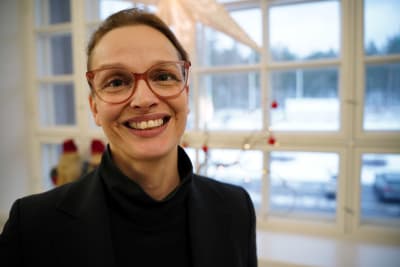 Raseborgs stadsdirektör Petra Theman leende framför ett fönster. 