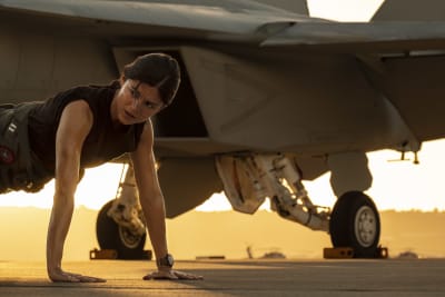 Nainen punnertaa hävittäjälentokoneen edessä. Top Gun: Maverick -elokuvasta.