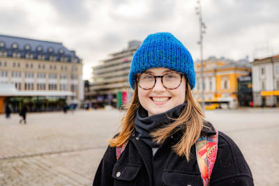 Kvinna i blå mössa på Åbo salutorg.