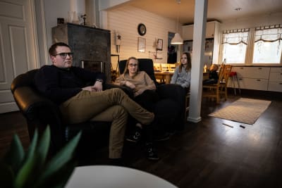 Tre personer sitter bredvid varandra i fåtöljer.