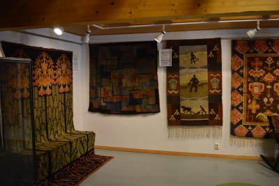 Fyra moderna ryor från 1900-talet, i jugendstil och abstrakta ryor, på en utställning i ett museum.