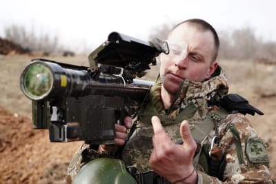En man i armékläder med ett luftvärnsvapen av typen Stinger på axeln