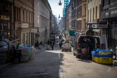 Drottninggatan i Stockholm. I förgrunden en bil som lastar möbler.