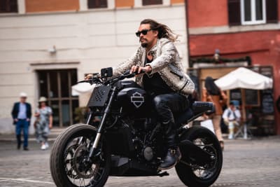 En man i solglasögon gasar fram på en enorm motorcykel.