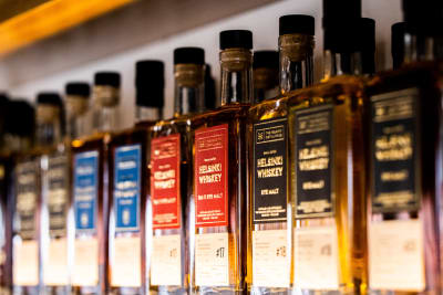 Flaskor med whiskey på rad i ett destilleri. 