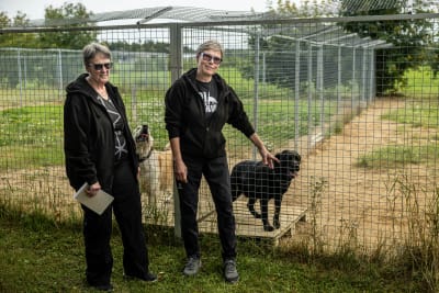 Två kvinnor i mörka kläder står framför hudhagar