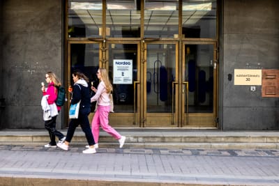 Unga kvinnor går förbi Nordeas bank.