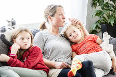 Familj som gosar i soffan.