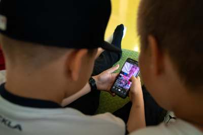 Barn som håller i en mobiltelefon och tittar på en video på Tiktok.