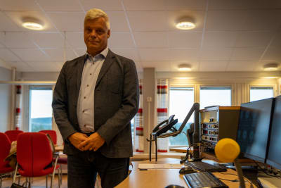 Lennart Poromaa tittar in i kameran. Står i ett kontrollrum med en telefon i bakgrunden.