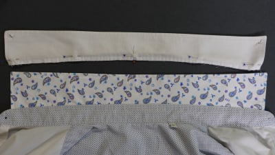 En närbild av ett sömnadsprojekt där en krage på en skjorta ska bytas till en ny.