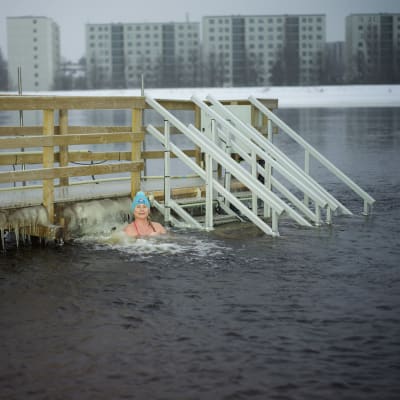 Salla Lamminpää on olkapäitään myöten kylmässä vedessä laiturin vieressä.