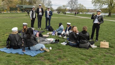 Studenter på picknick på gräsmatta. 