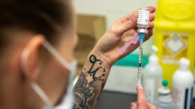 Astra Zeneca -rokotetta valmistava sairaanhoitaja Porvoon rokotuskeskuksessa. 18.3.2021.