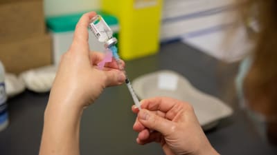 Astra Zeneca -rokotetta valmistava sairaanhoitaja Porvoon rokotuskeskuksessa. 18.3.2021.