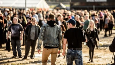 Två personer går mot en folkmassa på festivalen Rock Fest