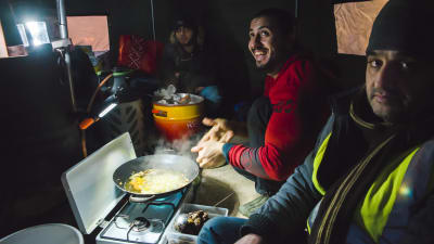 flyktingar lagar mat inne i tält