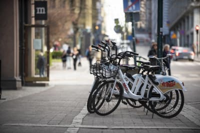 Moi.fi-merkkisiä kaupunkipyöriä pysäköitynä riviin kadulla.