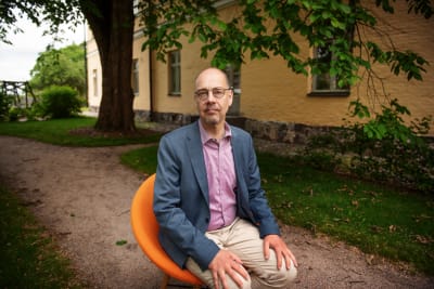 Kristian Wahlbeck sitter på en orange stol.
