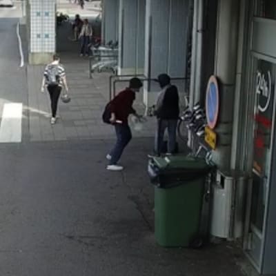 Valvontakameran kuvassa kaksi miestä ostoskeskuksen ulkopuolella, toisella puukko kädessä.