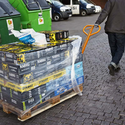 Mies vetää Virosta tuotuja olut- ja lonkerolaatikoita kohti autoa Helsingin Länsisatamassa torstaina 3. lokakuuta¨.