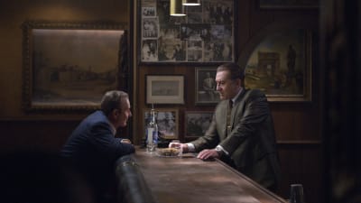 Russel Bufalino (Joe Pesci) och Frank Sheeran (Robert de Niro) sitter och står mittemot varandra vid en öde bardisk.
