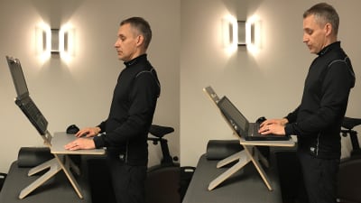 En man står vid sin laptop som ligger på ett litet bord. Bordet i sin tur står på en bänk så mannen får en optimal ståend arbetsställning.