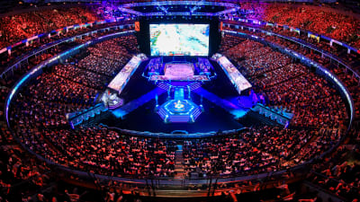 En fullsatt arena under The International, spelarna sitter i mitten.