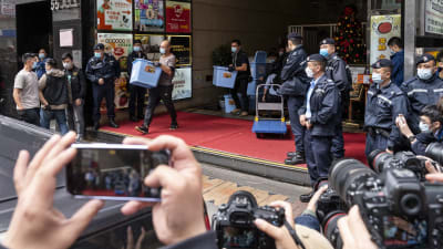 Polisen i Hongkong bär bort material under ett tillslag mot den prodemokratiska webbtidningen Stand News.