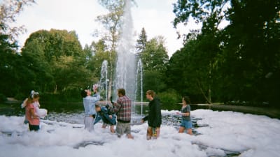 Filmteamet står i en fontän full med skum. 