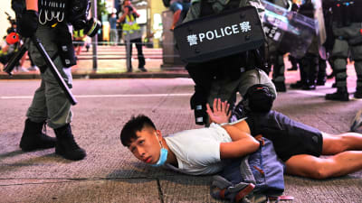 En demonstrant grips av polisen under protester mot den nya säkerhetslagen den 1 juli 2020.