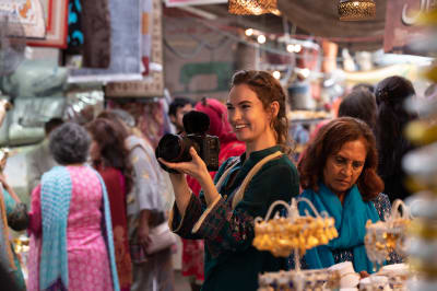Zoe (som spelas av Lily James) riktar sin filmkamera mot folkvimlet på en gata i Indien.  
