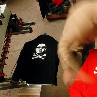 Chileläinen työntekijä painaa t-paitoihin kuvia.