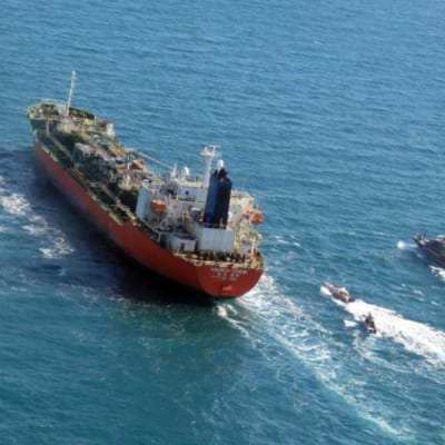 Bild på en tanker som eskorteras av mindre snabba båtar.