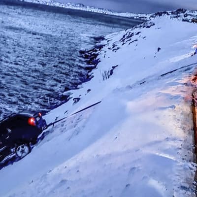 Tieltä suistunutta henkilöautoa vedetään jyrkästä rinteestä Pohjois-Norjassa 22.2.2019.