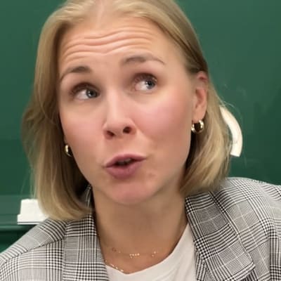 Toimittaja Sara Salmi kertoo kuningatar Elisabetin hautajaisista vihreän seinän edessä.