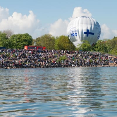 Ihmisiä ja Suomi100-kuumailmapallo Helsingin kaivopuiston rannassa.