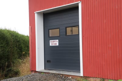 En röd byggnad med dörr med texten "inkommande produkter". 