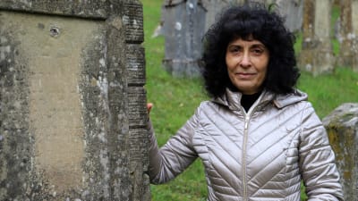 Rajaa Nadler står vid en gravsten på den judiska begravningsplatsen i Ermreuth