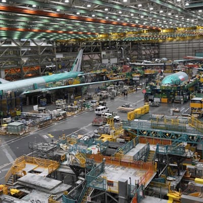 Lentokonetta valmistetaan suuressa teollisuushallissa.